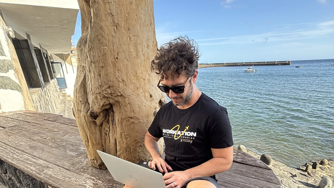 Persona trabajando con el portátil en una mesa junto al mar durante un workation en Gran Canaria