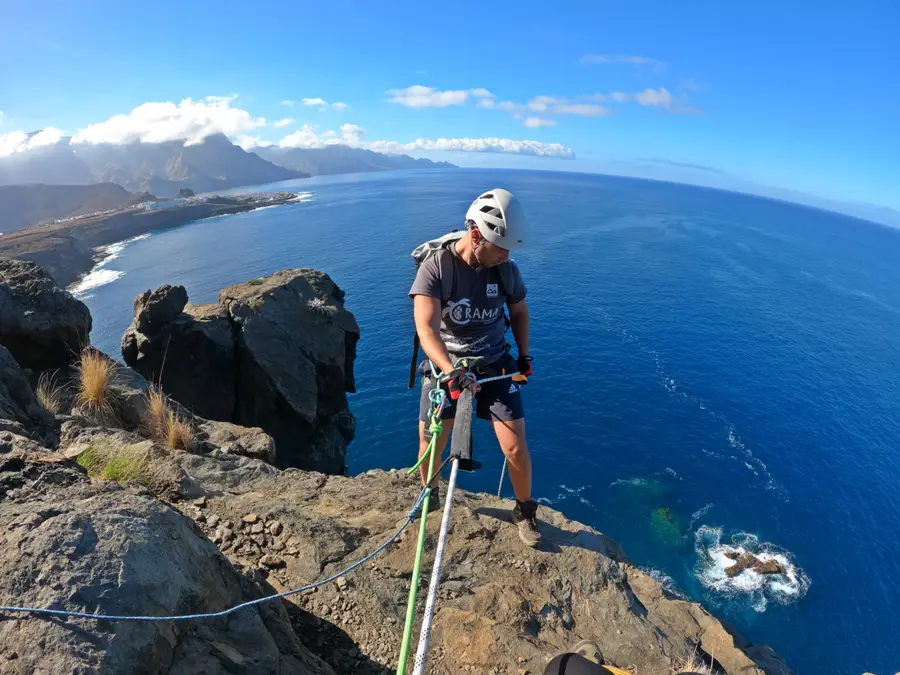 Persona haciendo coasteering en un acantilado sobre el océano en Gran Canaria