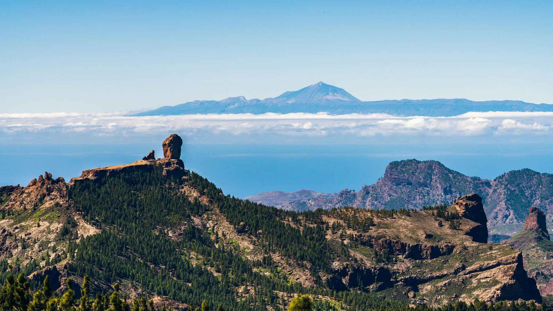 El Roque Nublo en el paisaje volcánico de Gran Canaria con el Teide y un mar de nubes al fondo