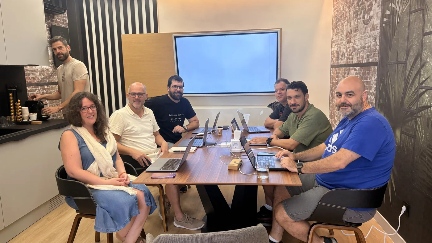 Equipo reunido alrededor de una mesa con portátiles en la sala de reuniones del coworking Oceanworking