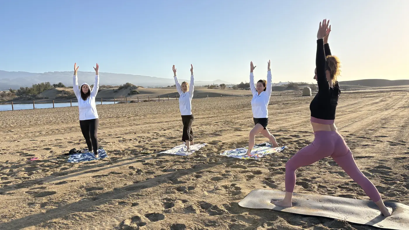 Sesión de yoga en grupo en una playa de Gran Canaria al amanecer
