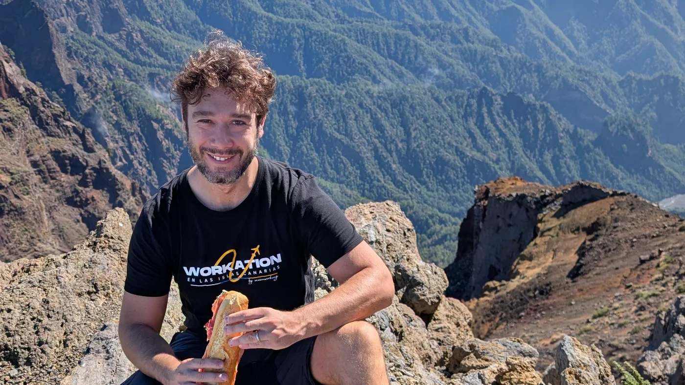 Persona sentada en una cima con vistas a las montañas de Gran Canaria
