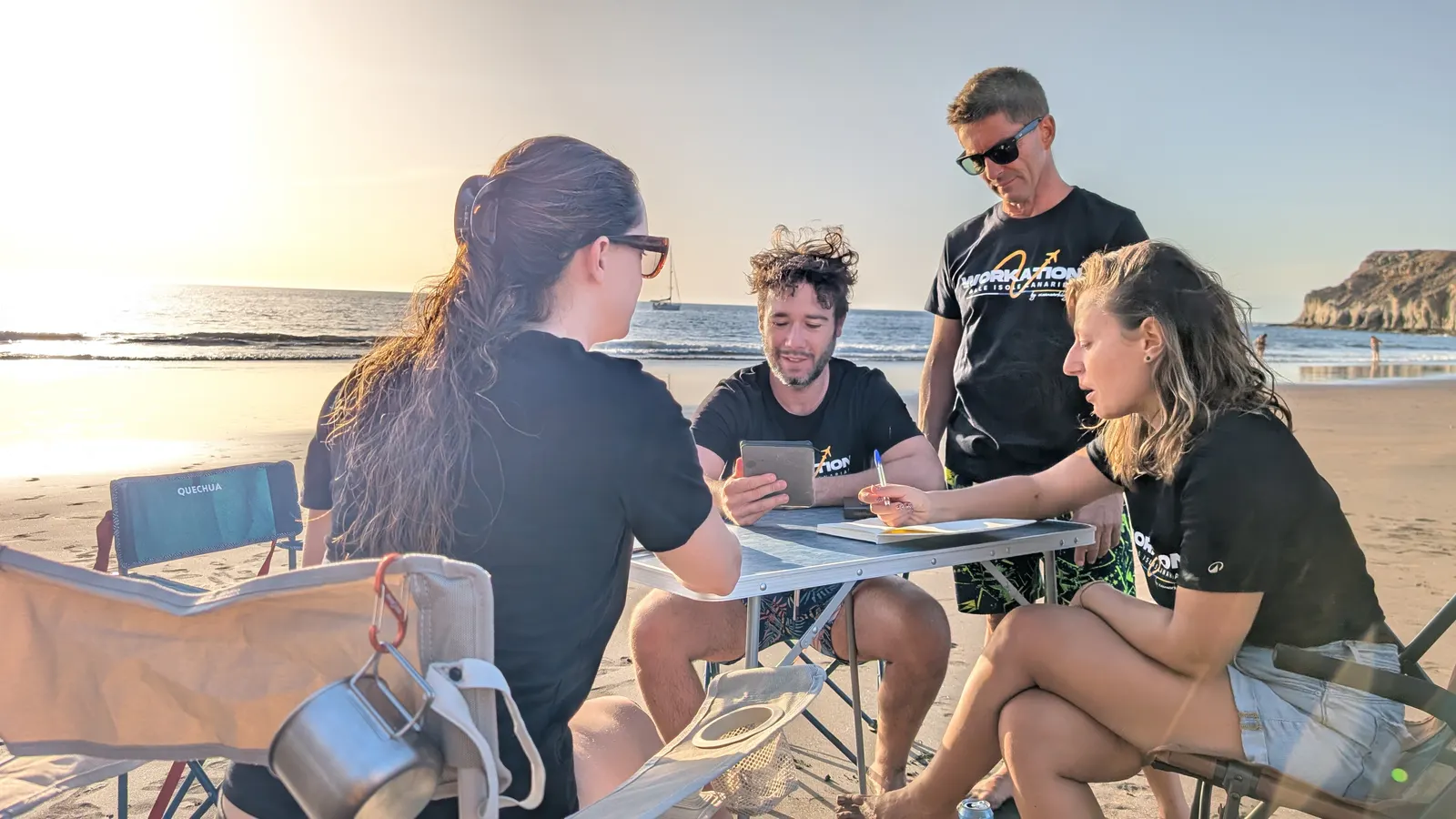 Grupo de participantes de un workation abrazados en una playa de Gran Canaria al atardecer