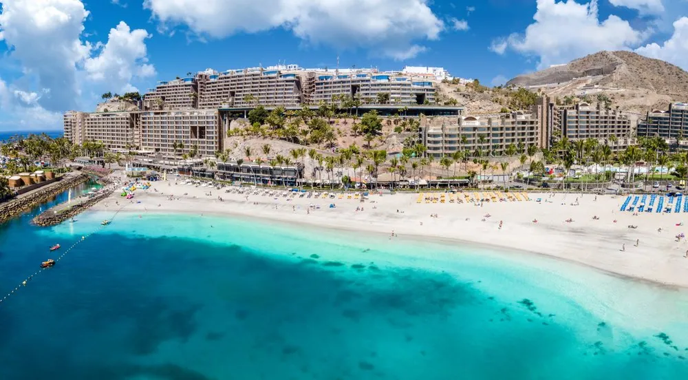 Strand von Anfi del Mar mit weißem Sand und ruhigem türkisfarbenem Wasser an der Südwestküste Gran Canarias.
