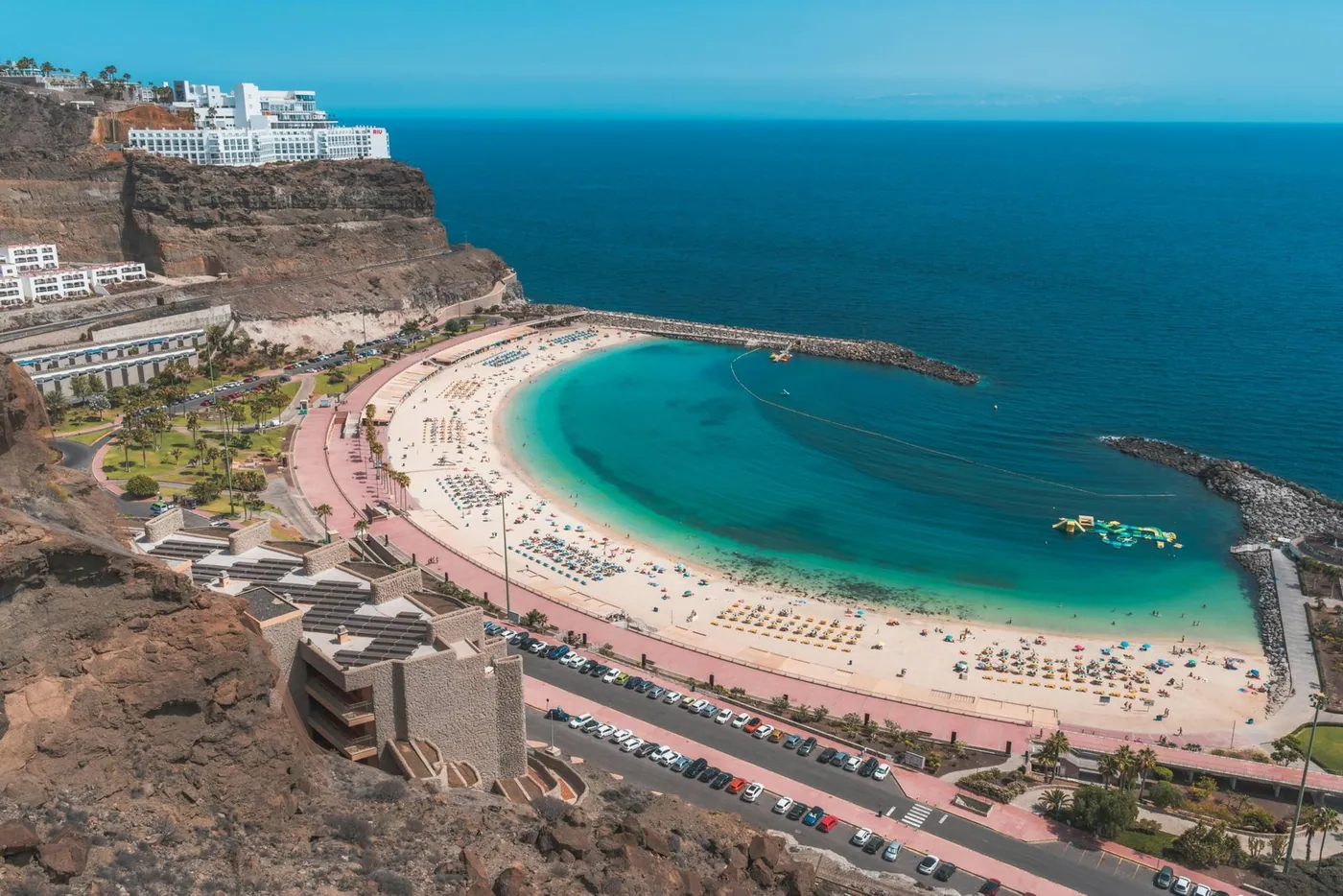 Die goldene Sandbucht der Playa de Amadores mit ruhigem Wasser und der Strandpromenade an der Südwestküste Gran Canarias