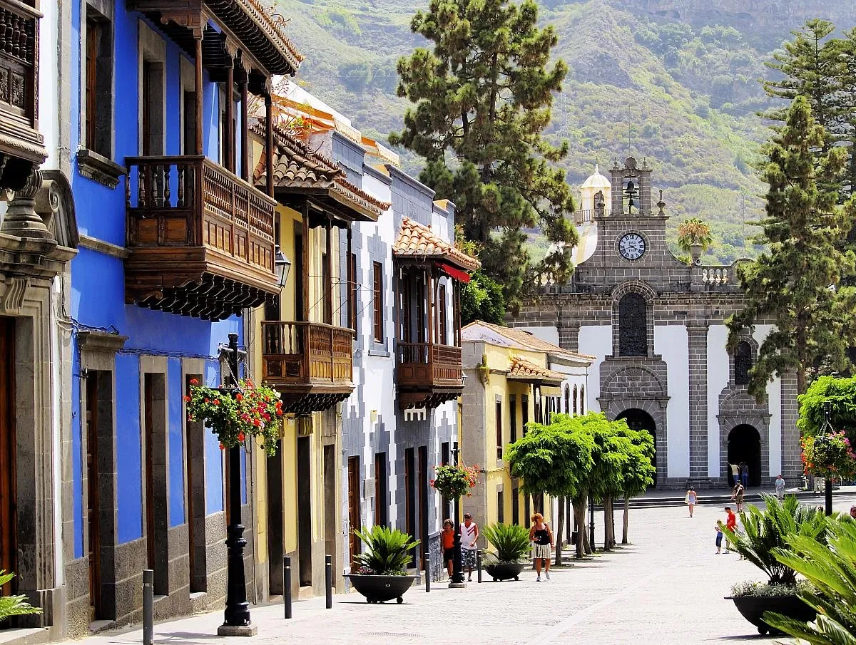 Gepflasterte Straße in Teror mit traditionellen Häusern und Holzbalkonen unter dem Himmel im Norden Gran Canarias